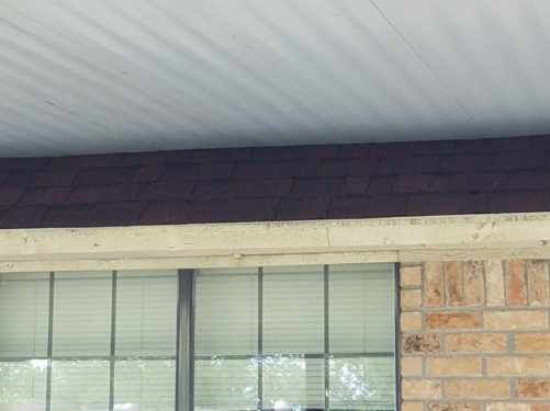 A brick building with a window and a roof.