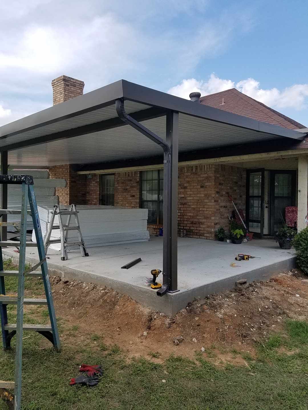 A patio cover is being built on the side of a house.