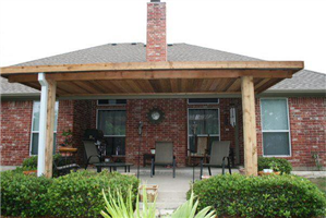 A brick house with a wooden porch and chairs