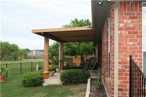 A brick house with a wooden pergola in the backyard