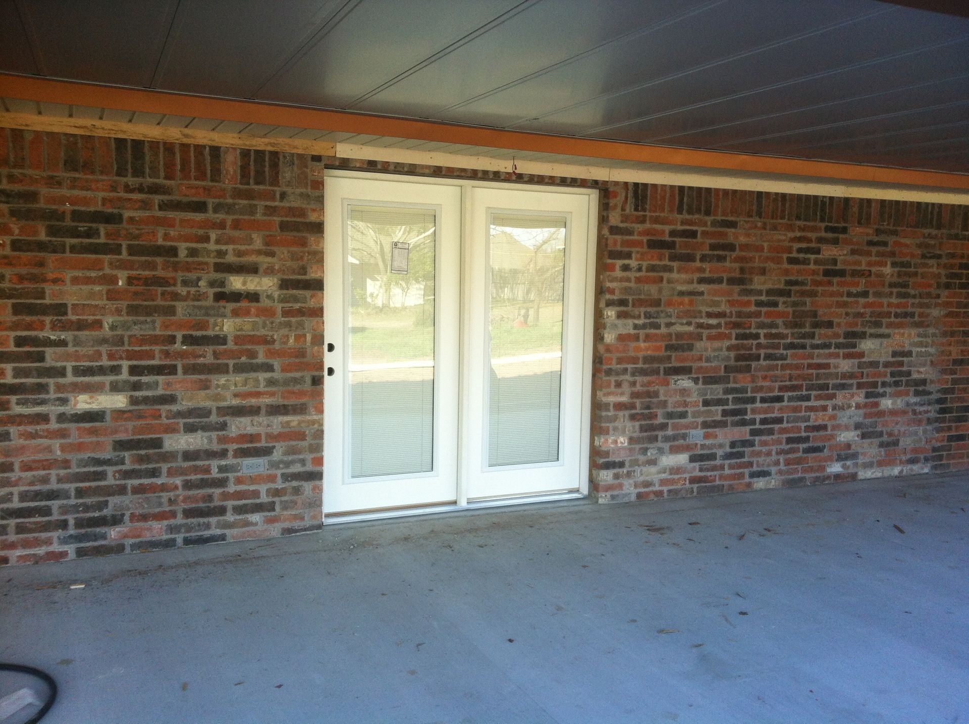 A brick wall with a white door on it
