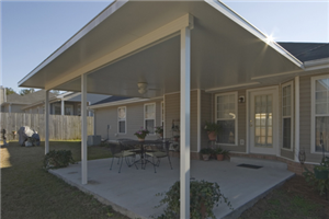 A house with a covered patio with a table and chairs