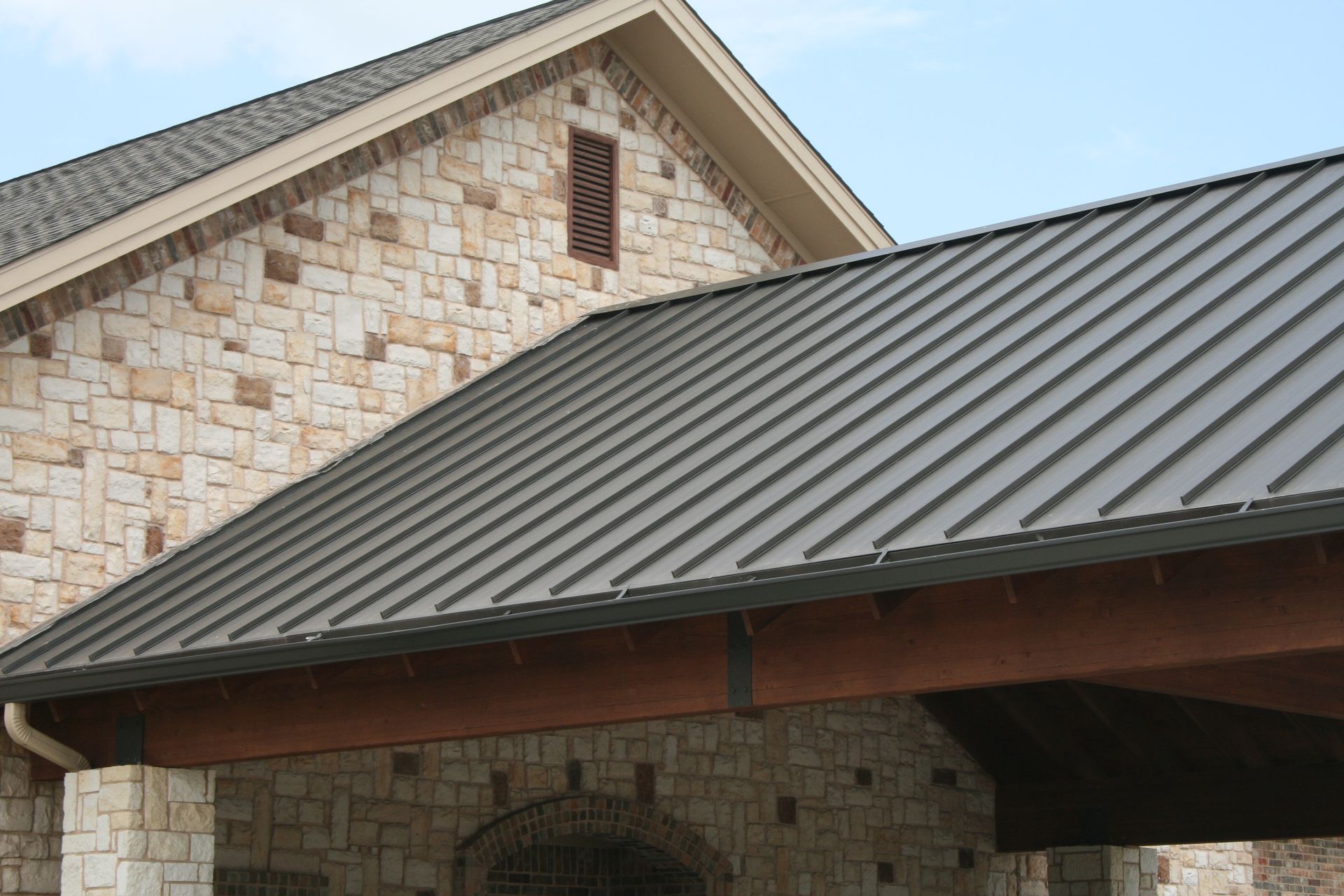 A building with a metal roof and a stone wall