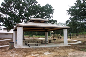 A white gazebo with a picnic table underneath it