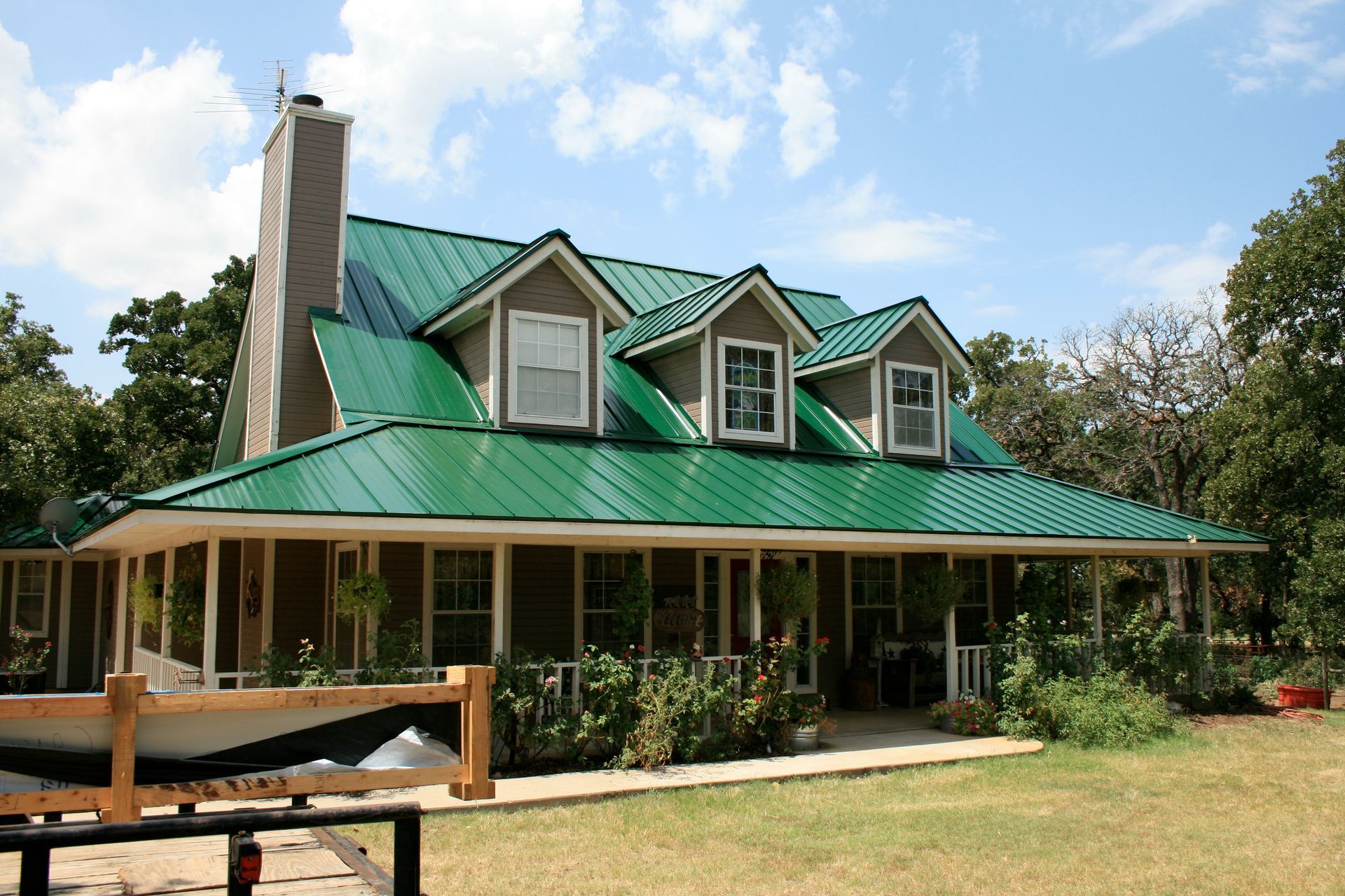A house with a green roof and a boat in front of it