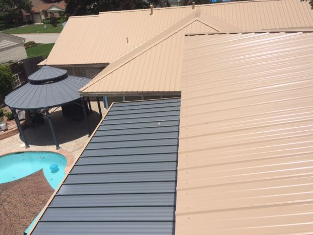 The roof of a house with a gazebo and a pool in the background.