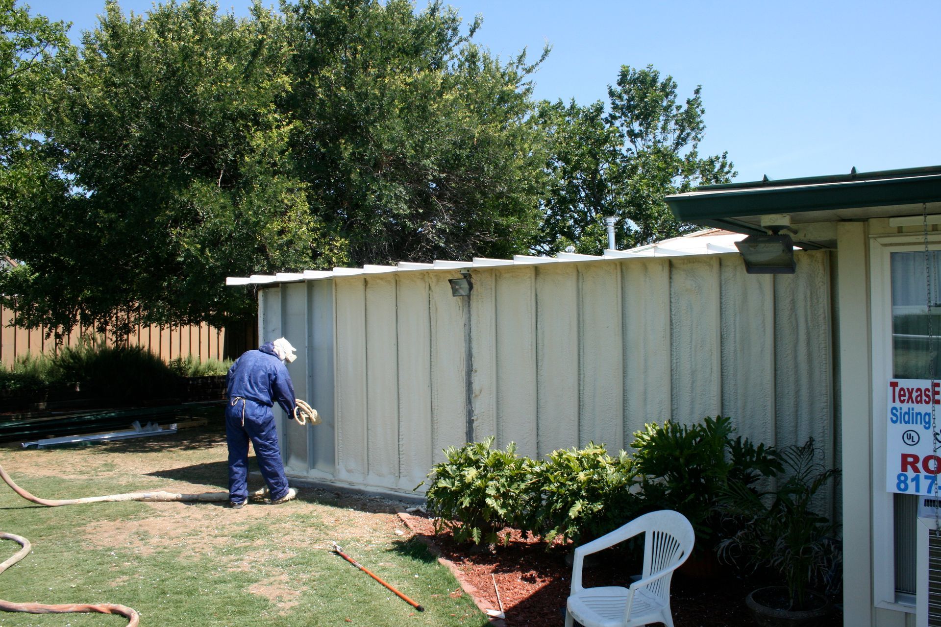 A man is spraying paint on the side of a building