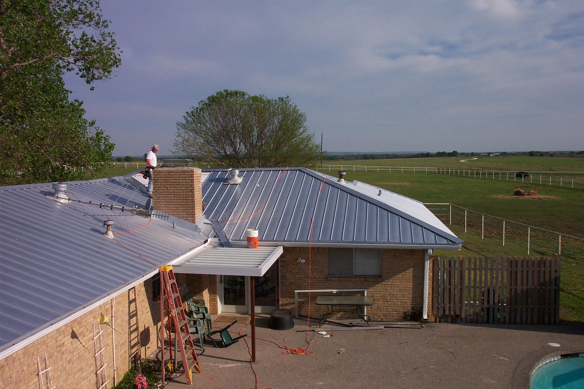 A man is standing on the roof of a house