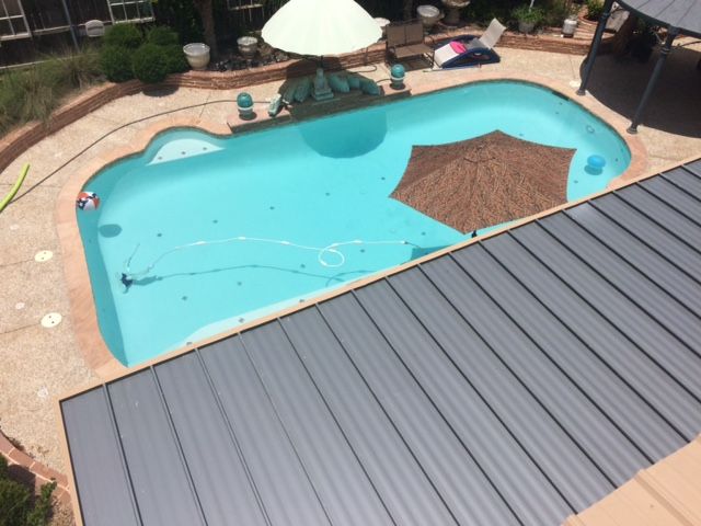 An aerial view of a large swimming pool with an umbrella