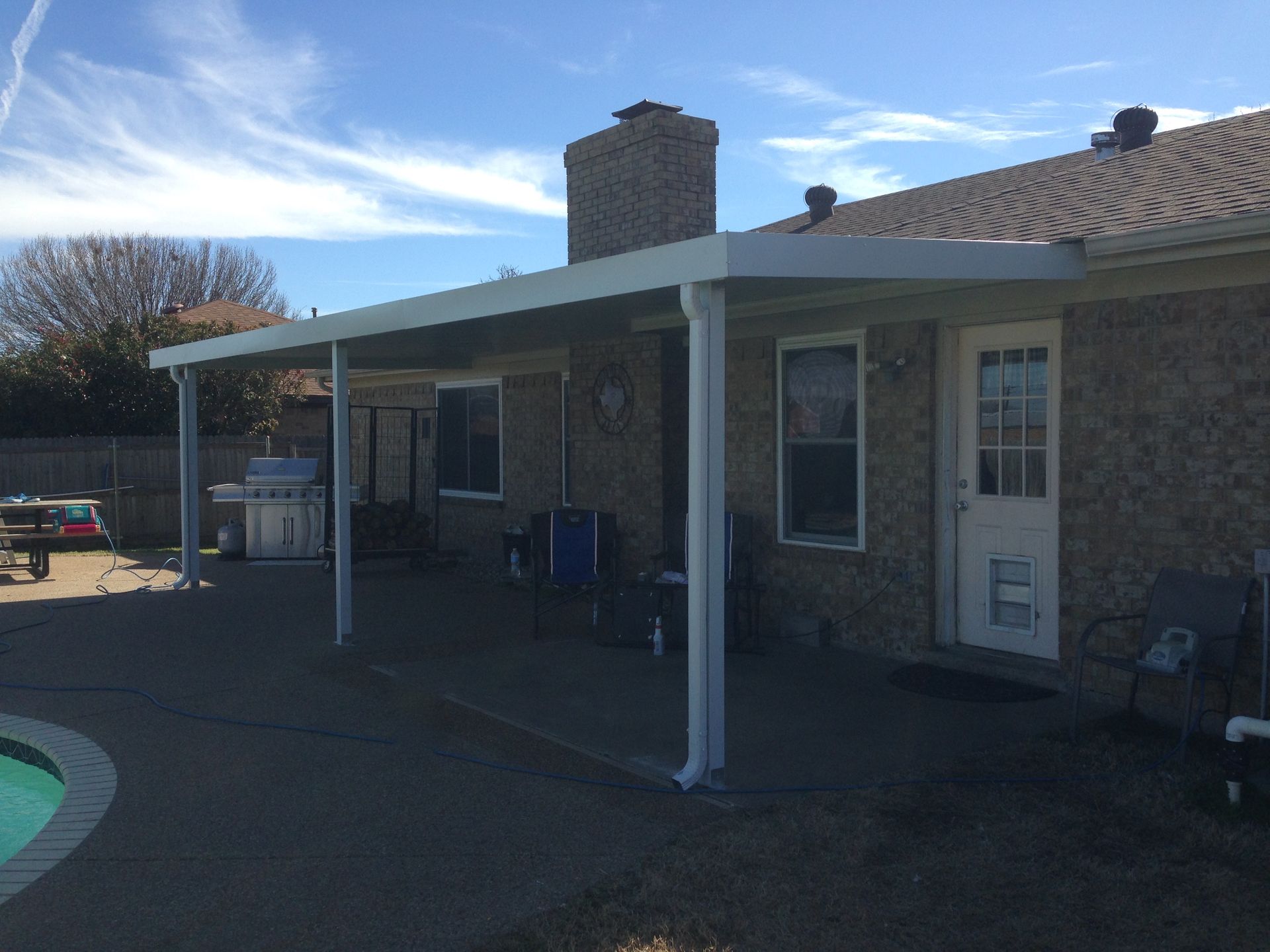 A house with a covered patio and a pool in the backyard.