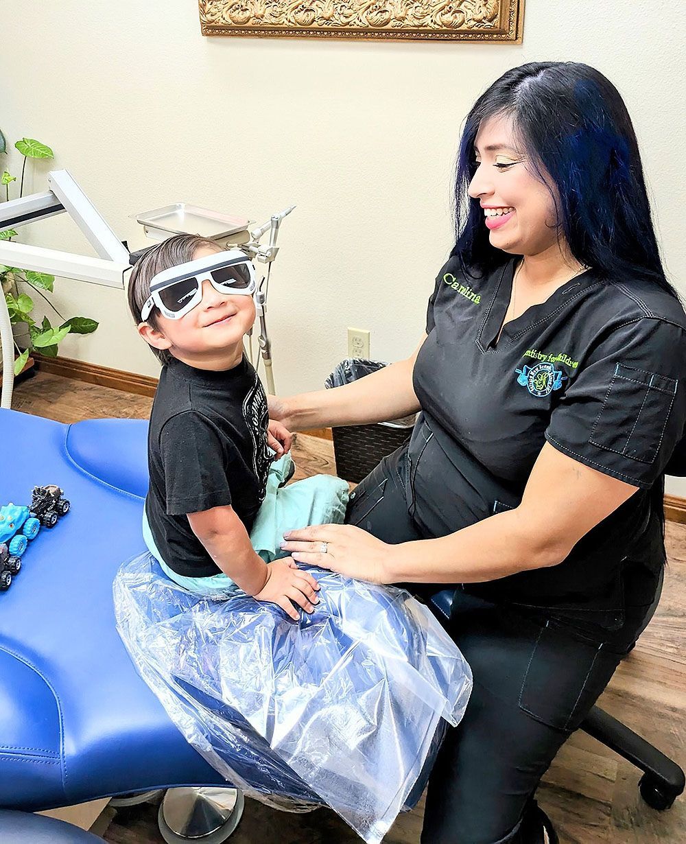 A woman is sitting next to a young boy wearing sunglasses.