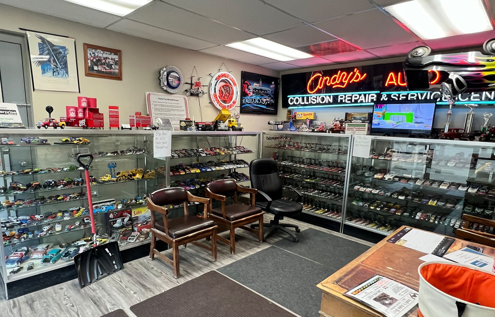 A room filled with lots of toy cars and a sign that says ' omega ' on it