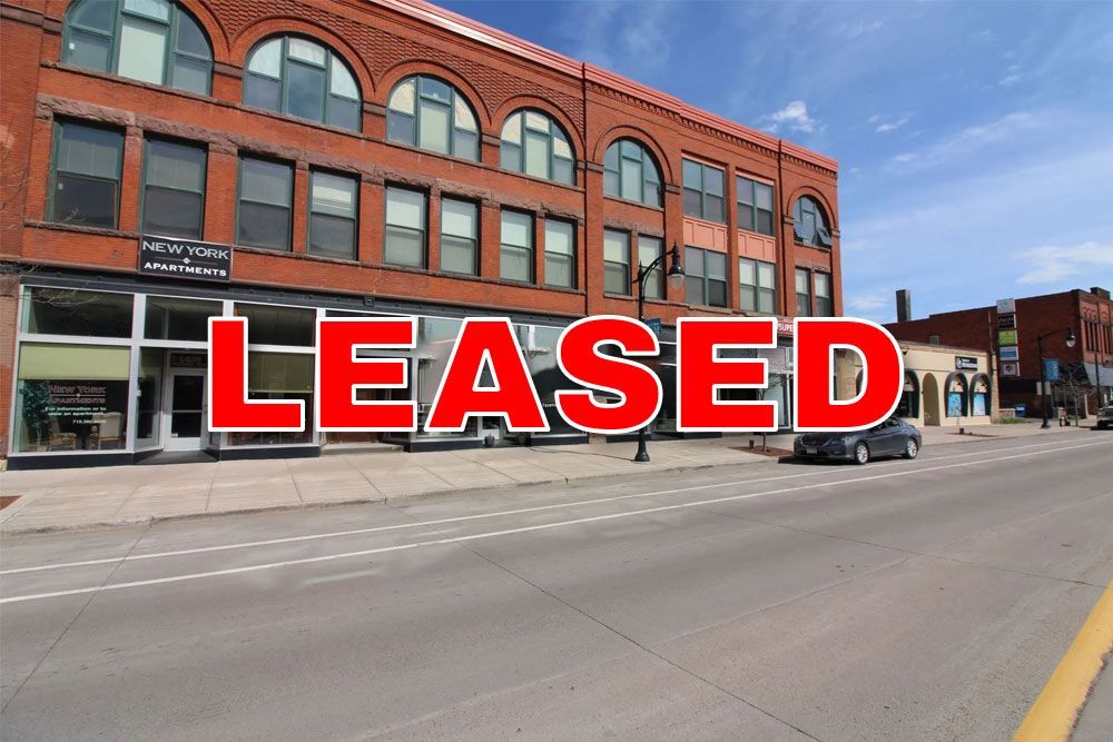 a car is parked in front of a large brick building