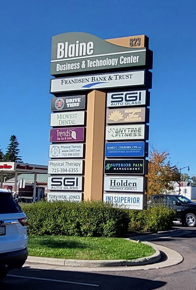 Sign for Blaine Business & Technology Center with tenant signs, against a blue sky.