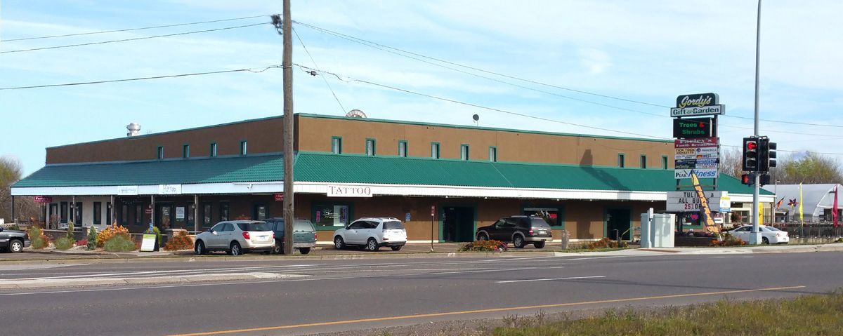 A large building with a green roof and cars parked in front of it.