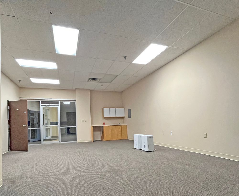 An empty room with a carpeted floor and a door