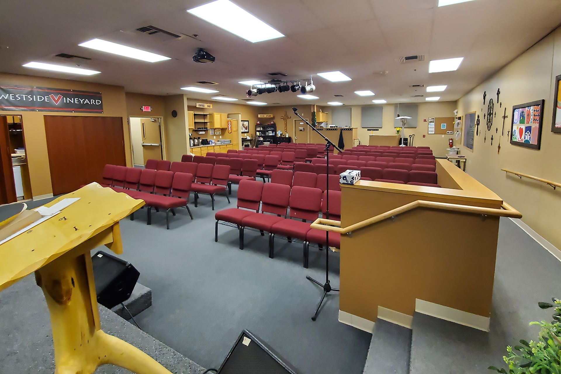 A large auditorium with rows of red chairs and a podium.