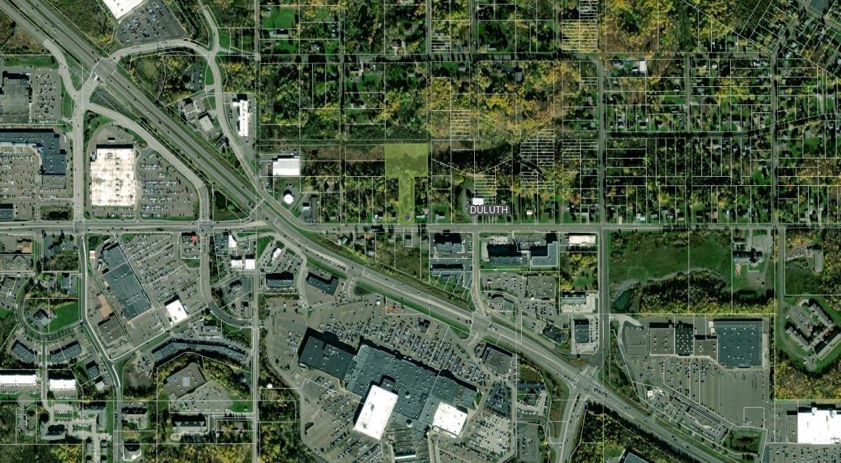 An aerial view of 1611 Maple Grove Rd Duluth, MN 55811 with lots of buildings and trees.