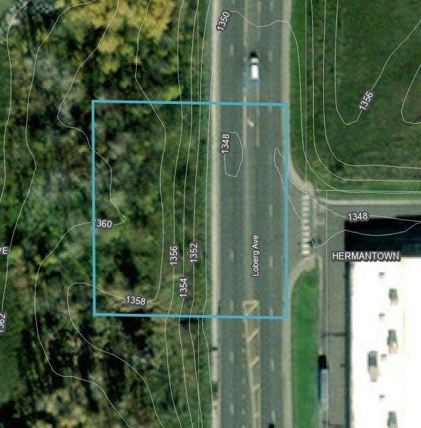 an aerial view of a road with a blue square in the middle