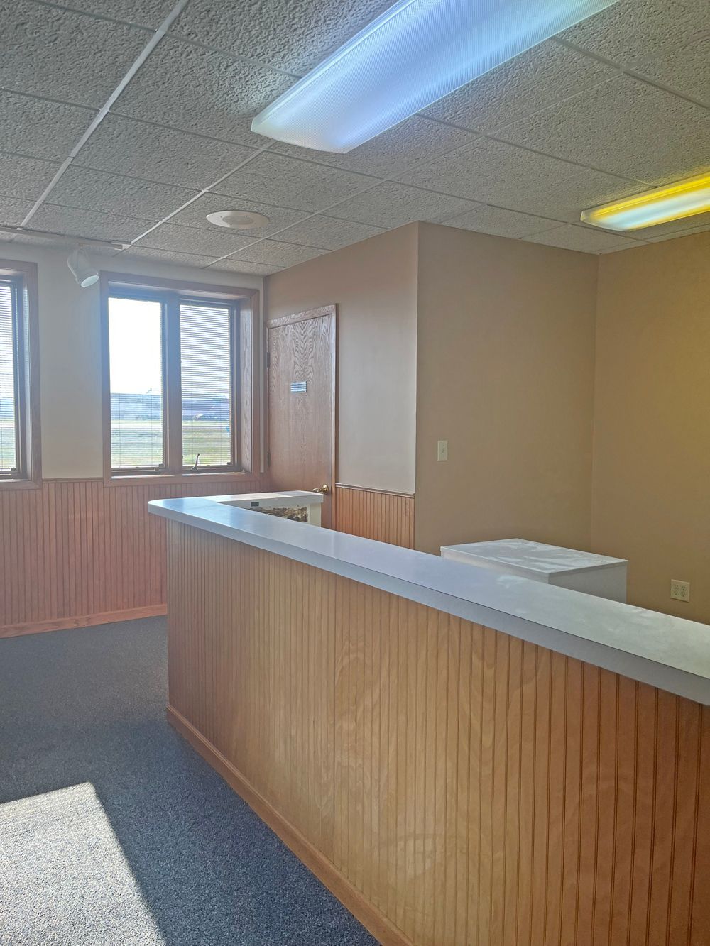 an empty room with a wooden counter and a window