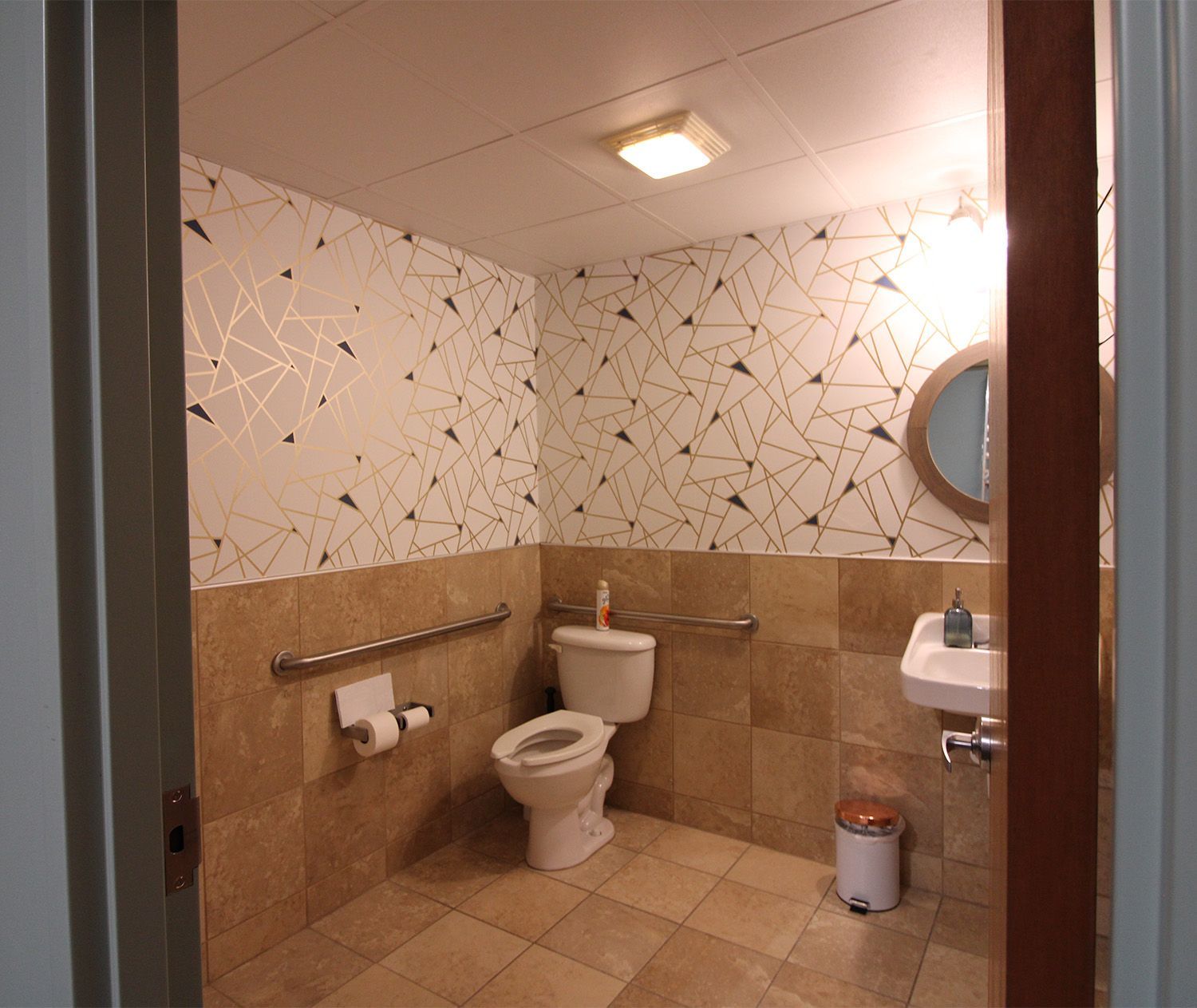 A bathroom with a toilet a sink and a mirror