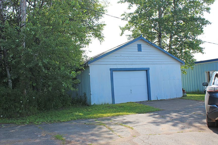 a car is parked in front of a blue garage