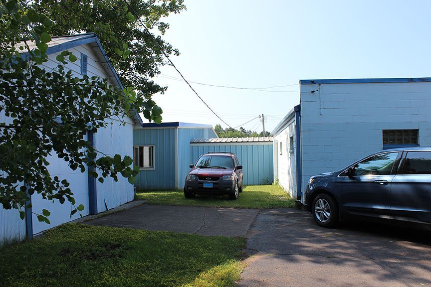 a red car is parked in front of a blue building