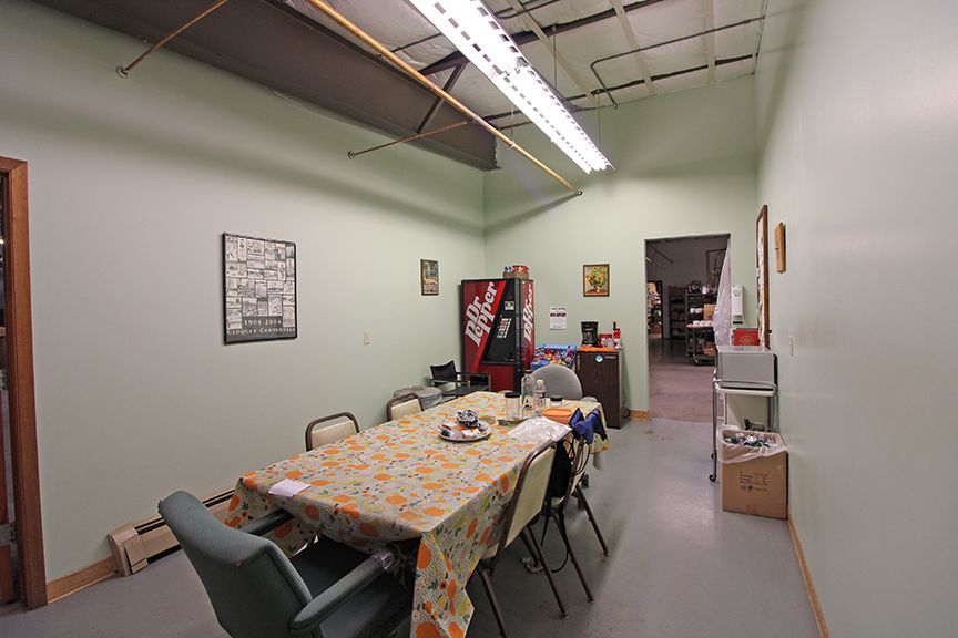 a room with a table and chairs and a coke machine