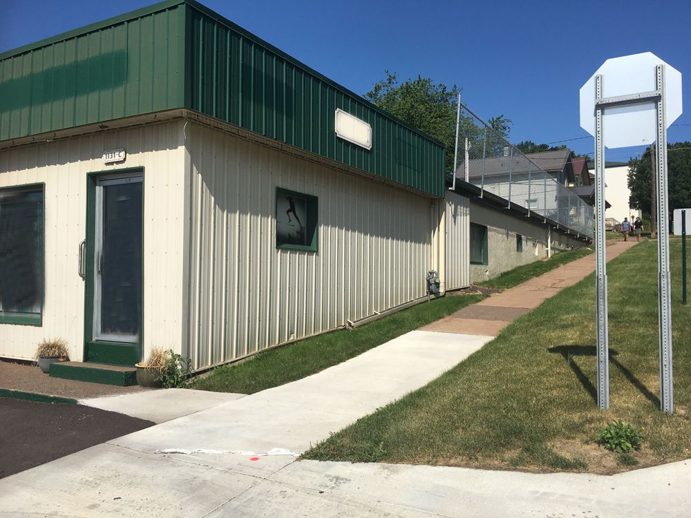 a building with a green roof is next to a sidewalk