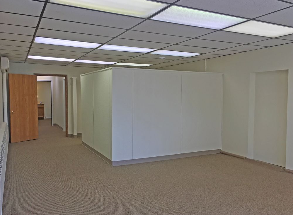 a large empty room with white walls and tan carpet