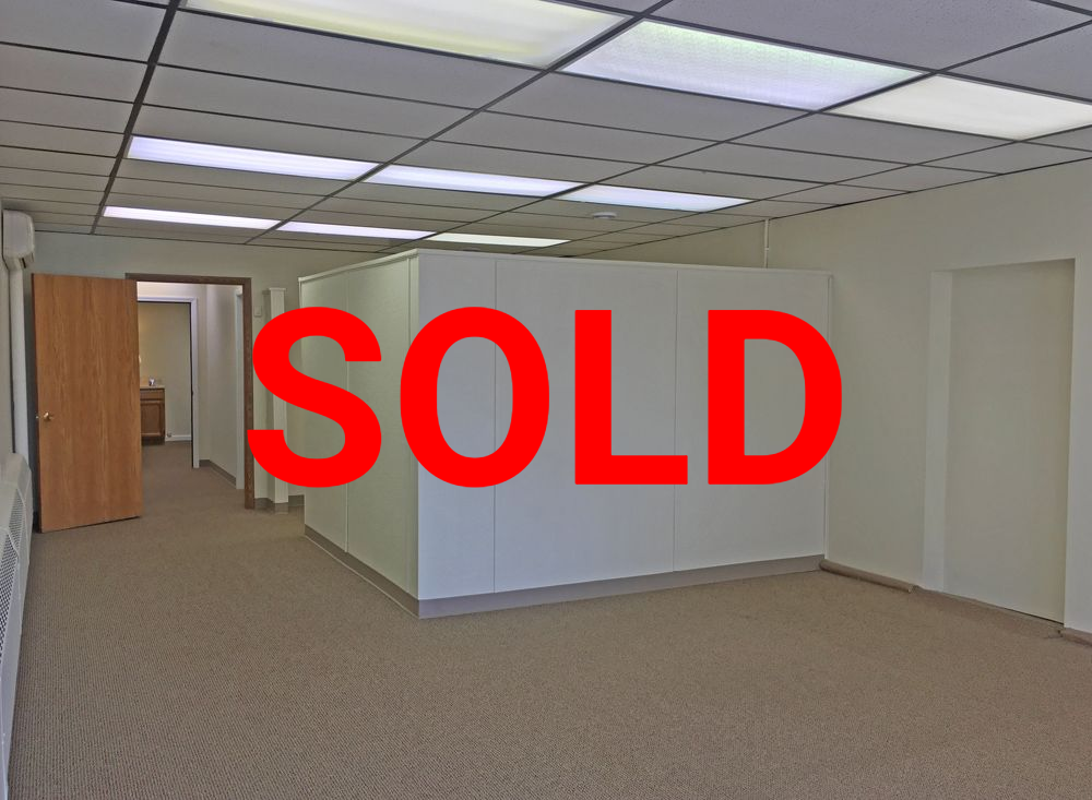 a large empty room with white walls and tan carpet