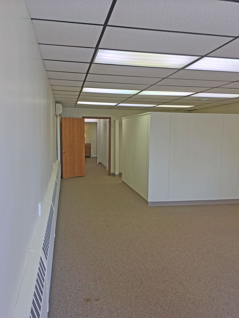 an empty hallway with a carpeted floor and white walls