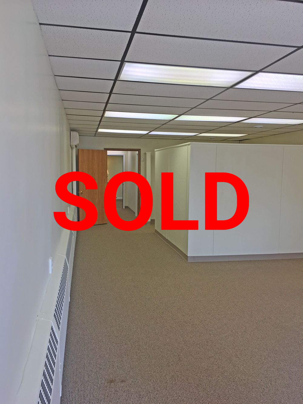 an empty hallway with a carpeted floor and white walls