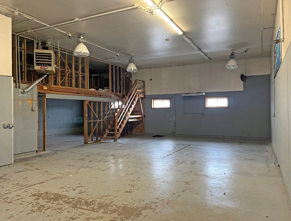 a large empty room with a staircase leading to a second floor