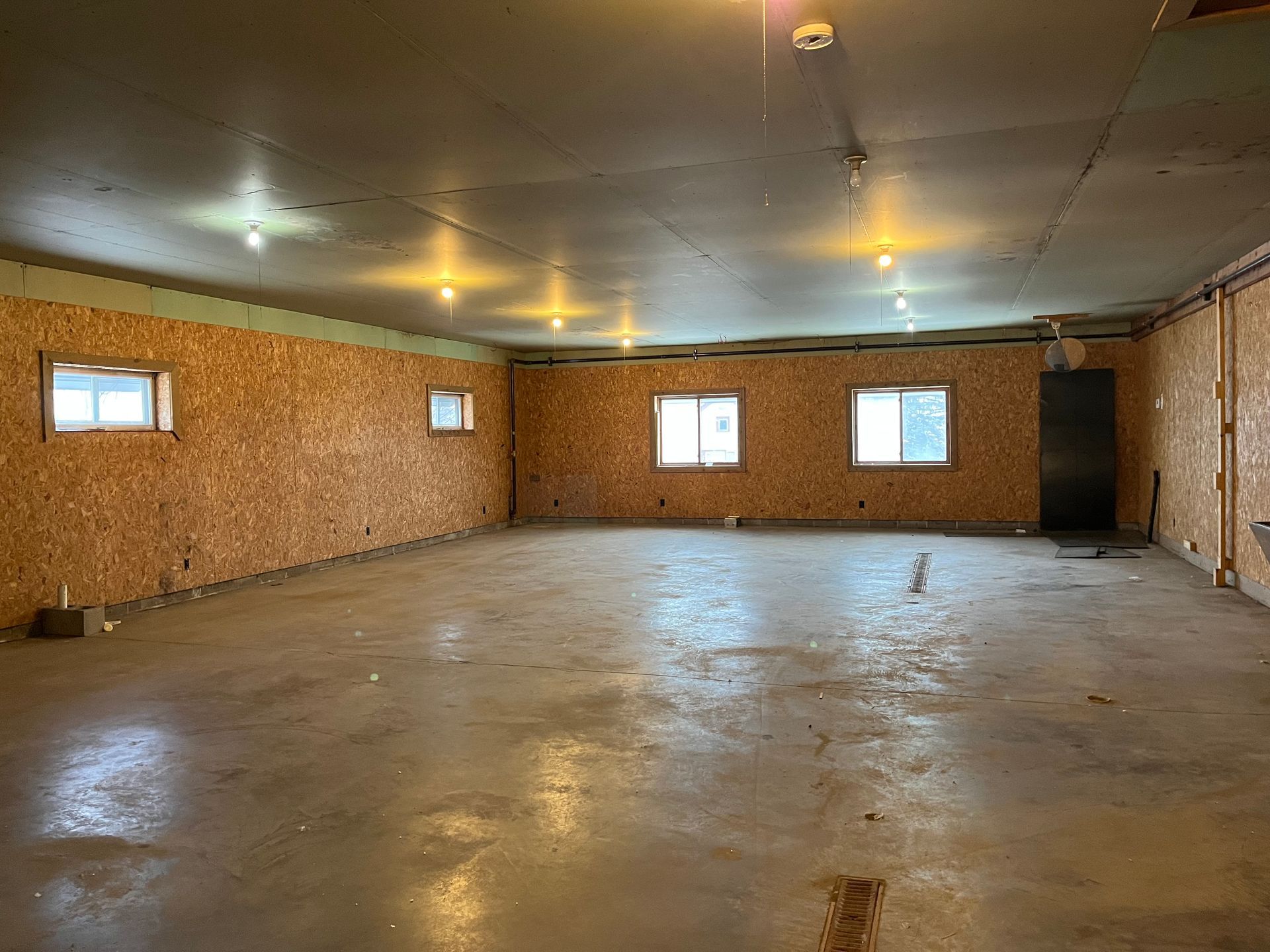 a large empty room with a lot of windows and a concrete floor