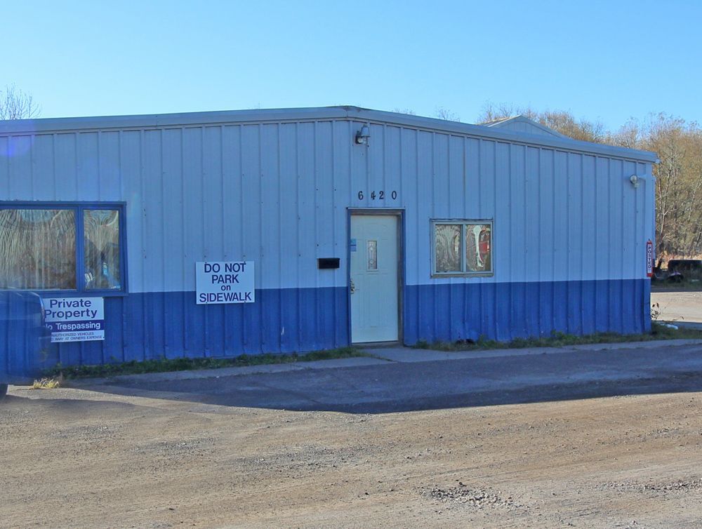 Blue commercial building with private property and no-parking signs.
