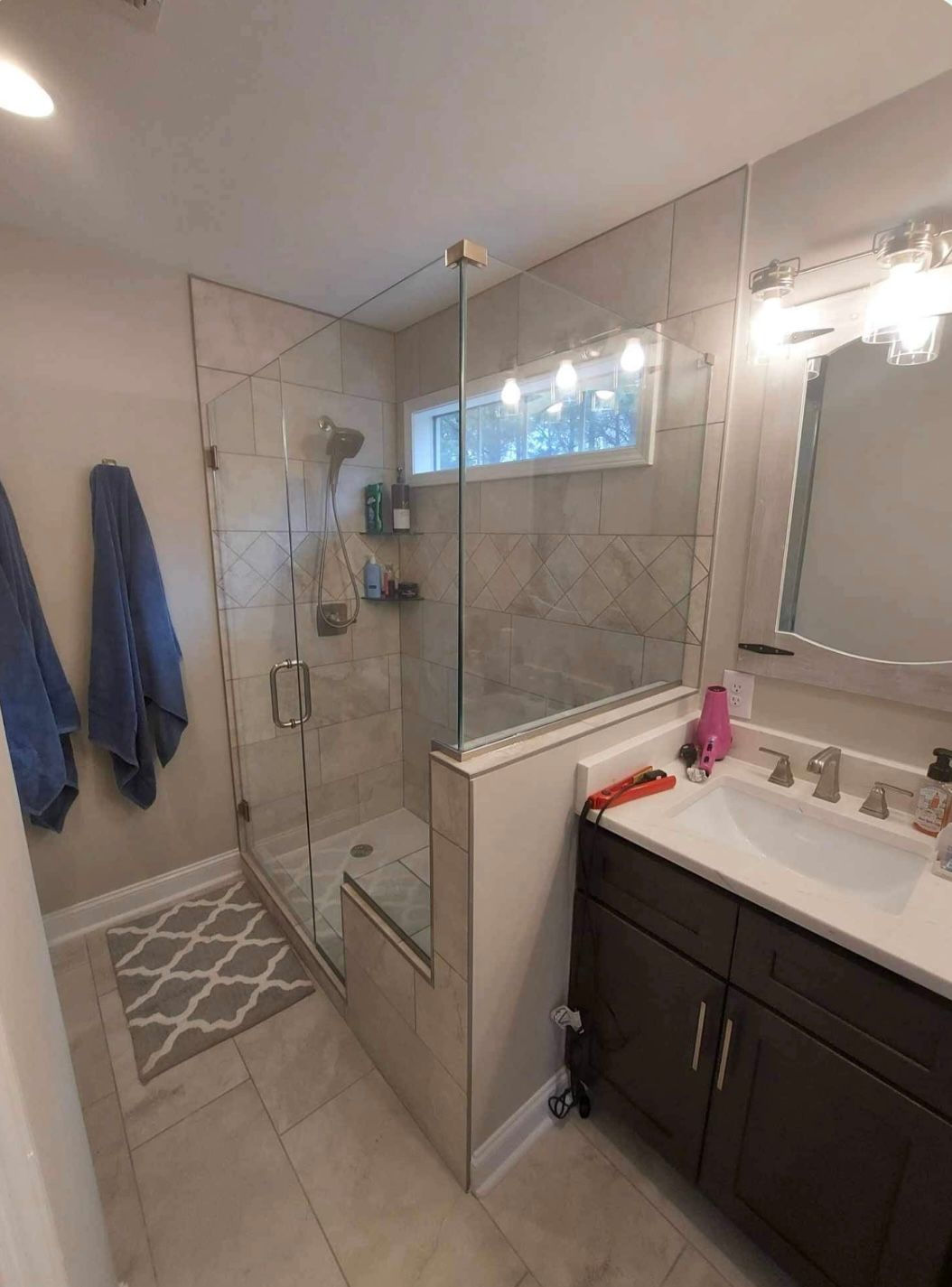 a bathroom with a sink , mirror and walk in shower