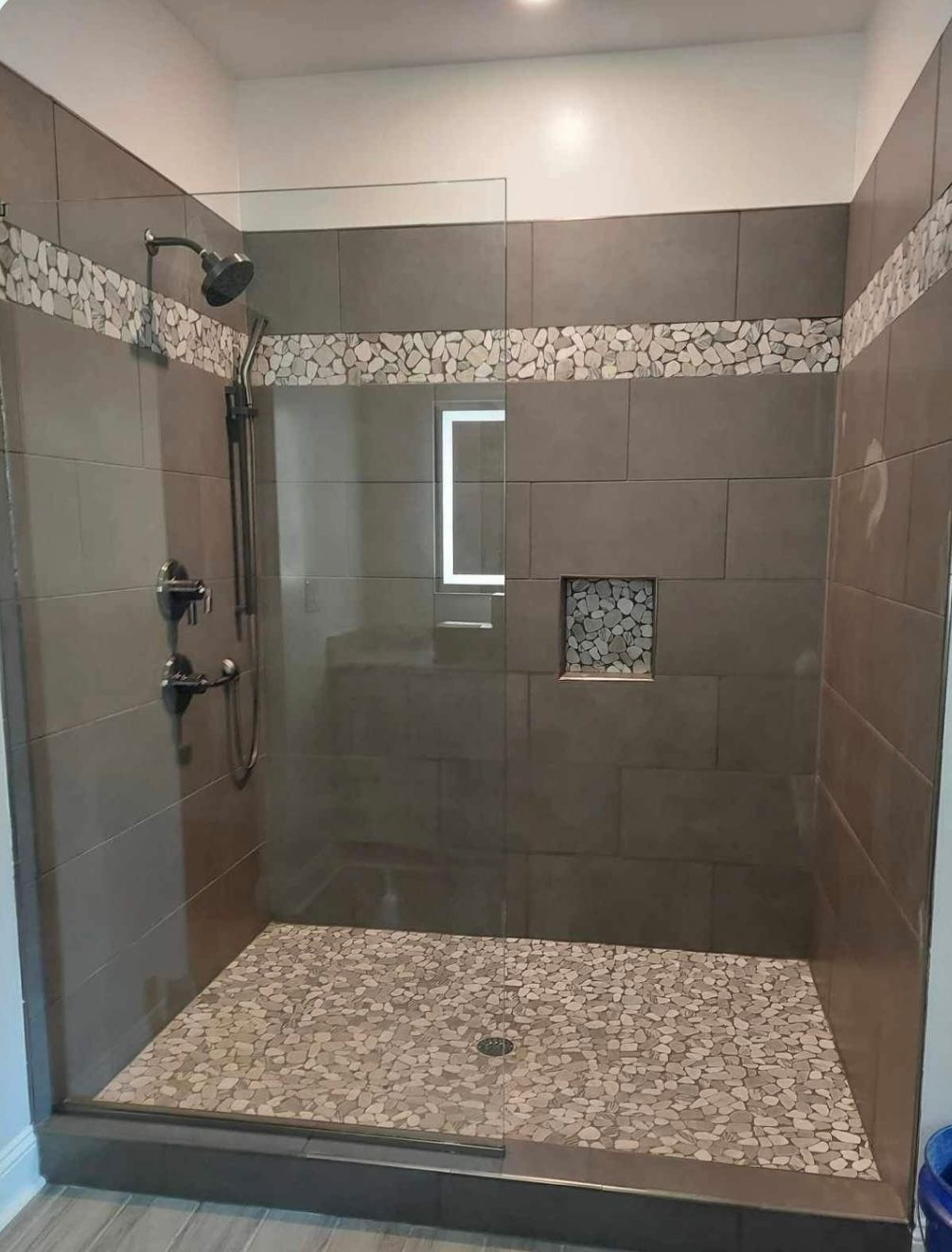 a bathroom with a walk in shower with a glass door