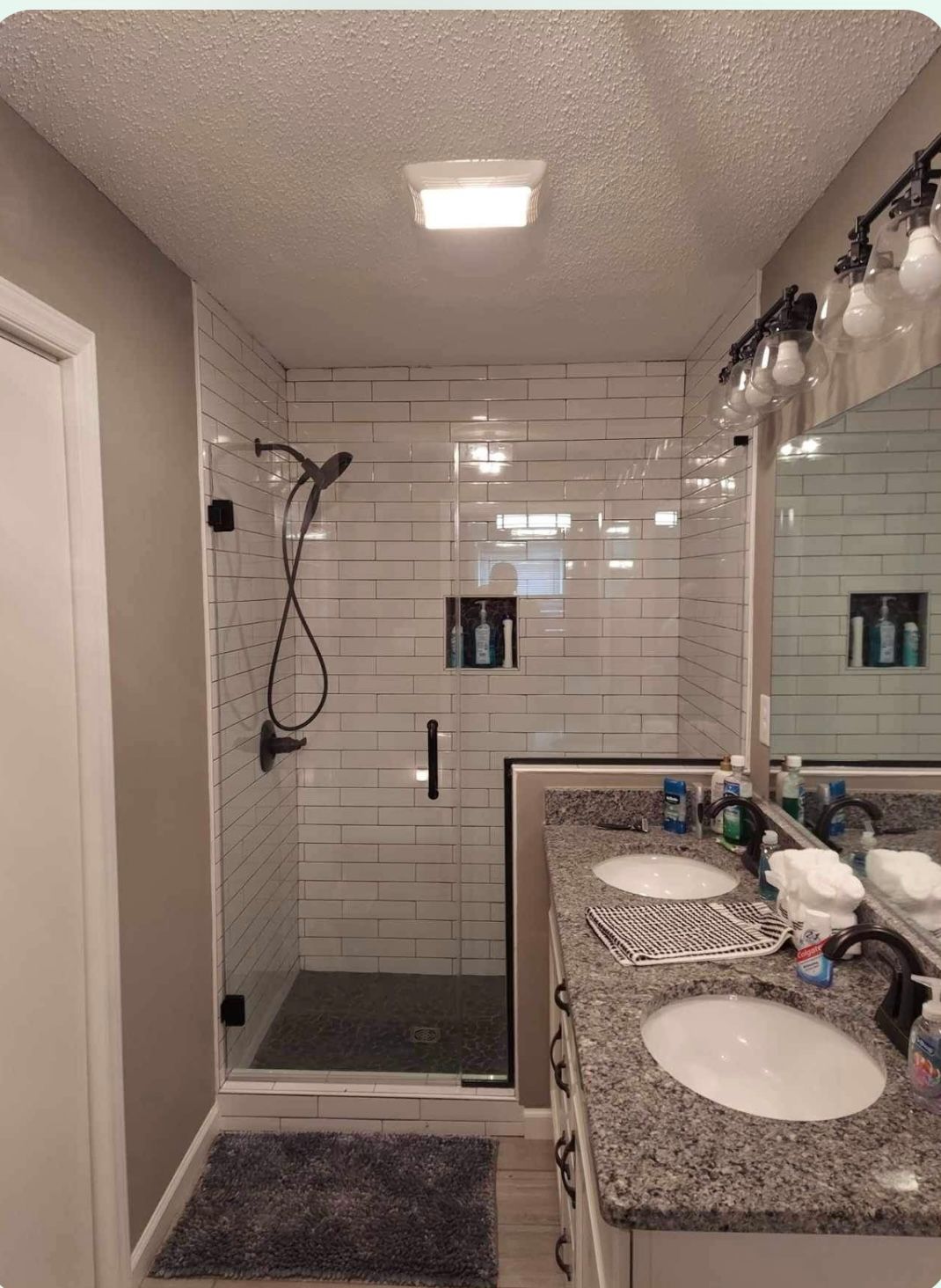 a bathroom with two sinks and a walk in shower