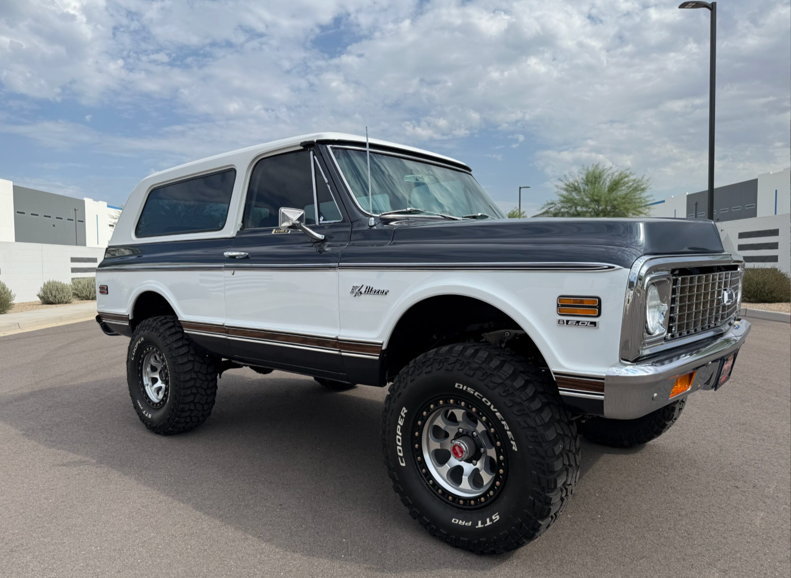 Classic white and dark blue lifted SUV parked outdoors on a sunny day