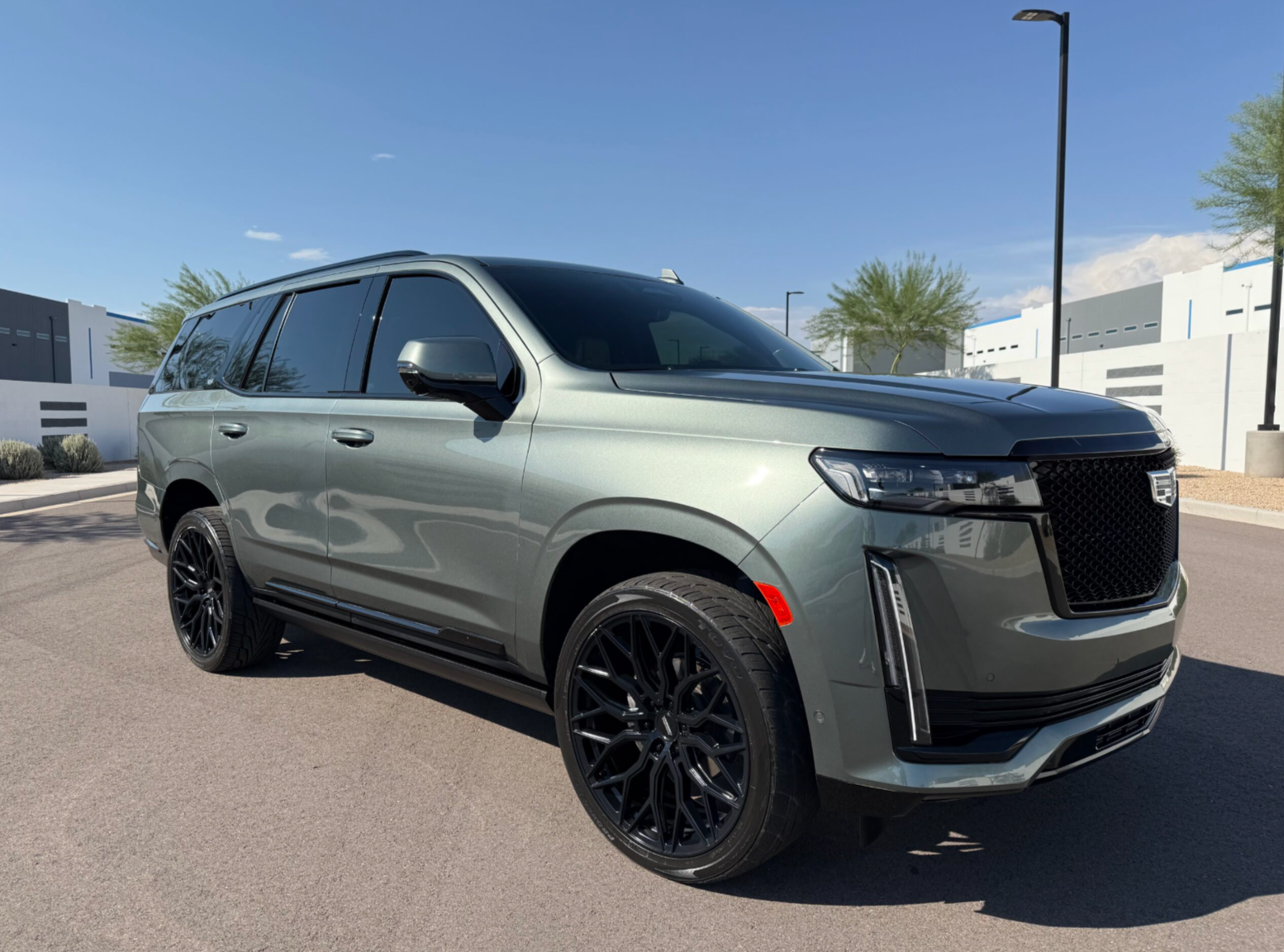 Gray SUV with black rims parked outdoors in a sunny lot