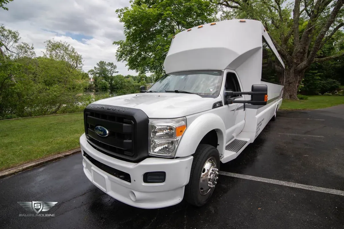 White Ford Super Duty truck with custom camper shell, parked outdoors.