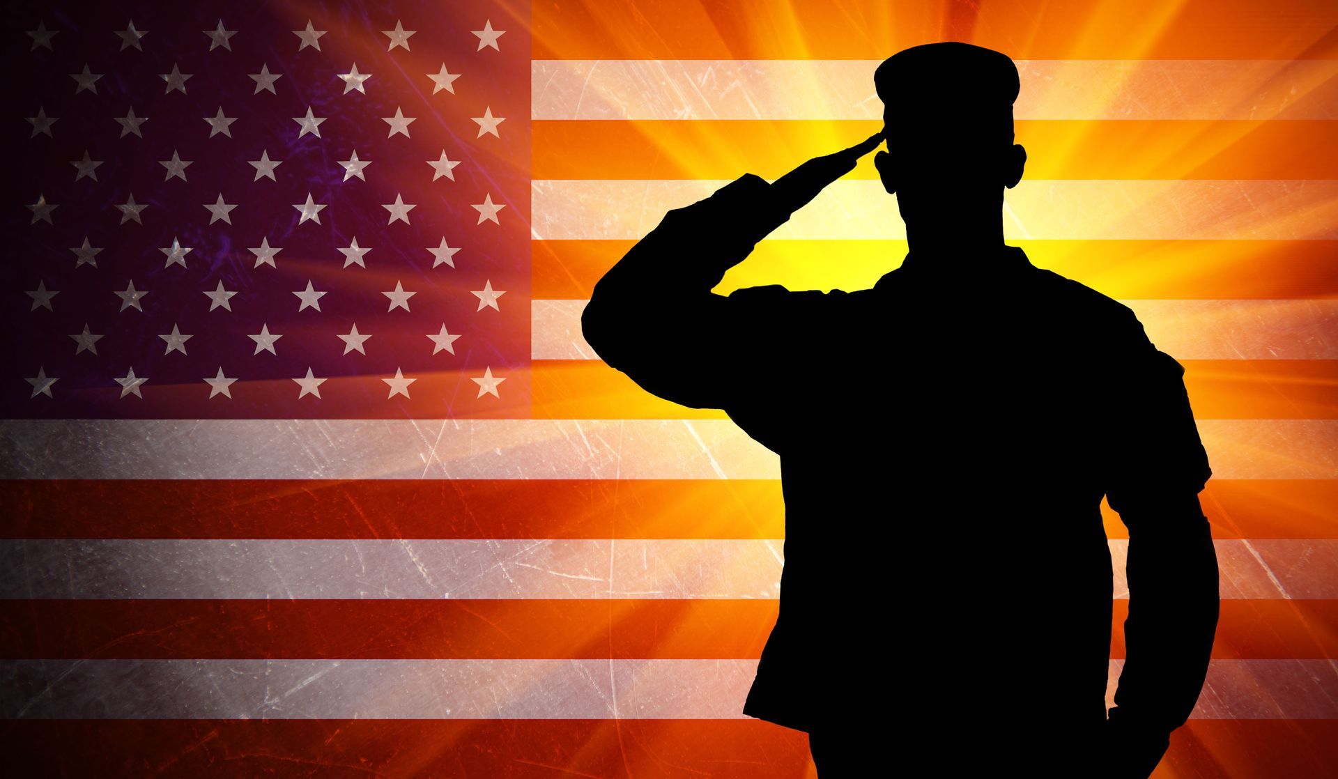 Silhouette of a saluting soldier before a waving American flag background