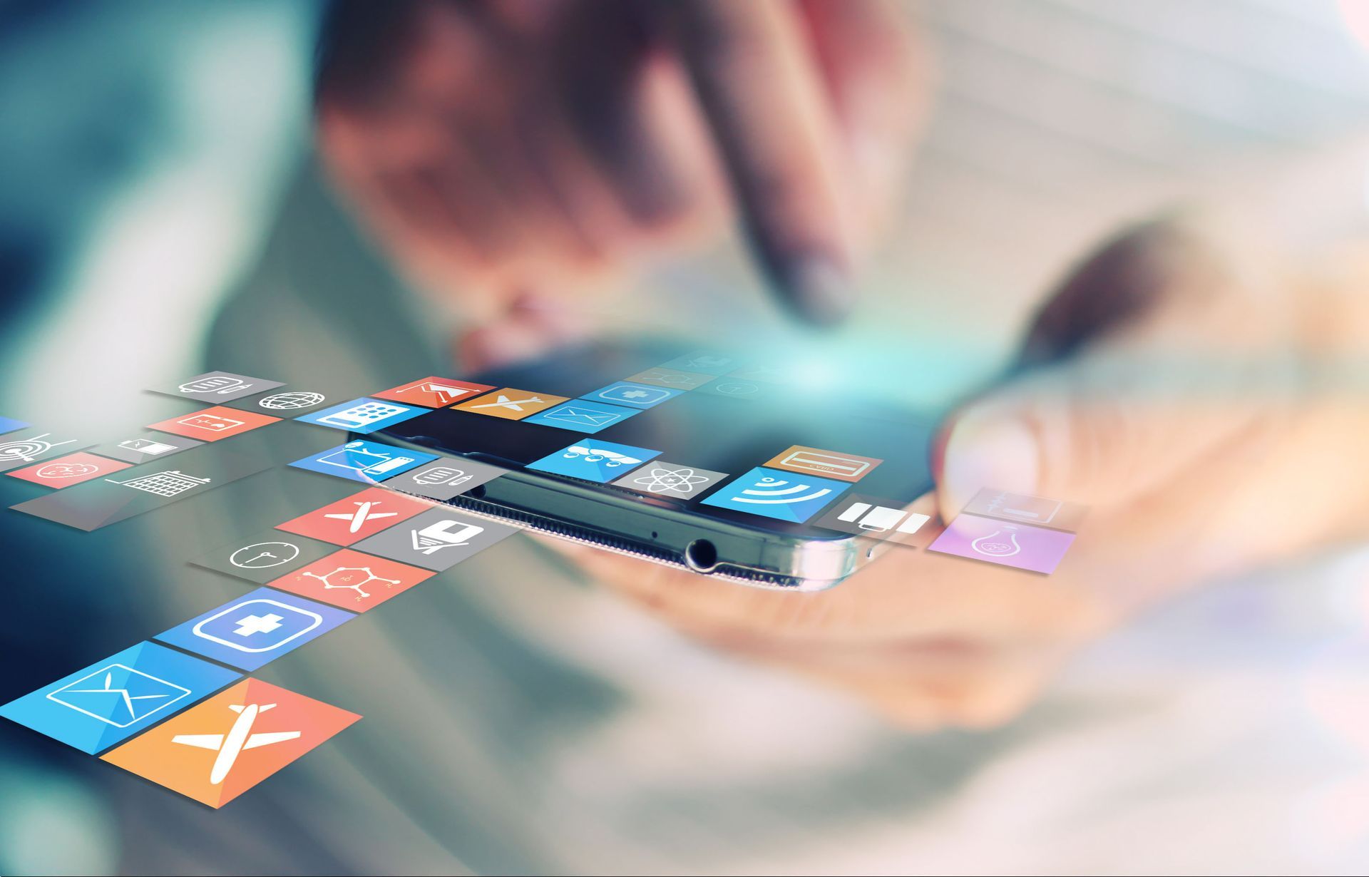 Person using a smartphone with colorful app icons floating above the screen