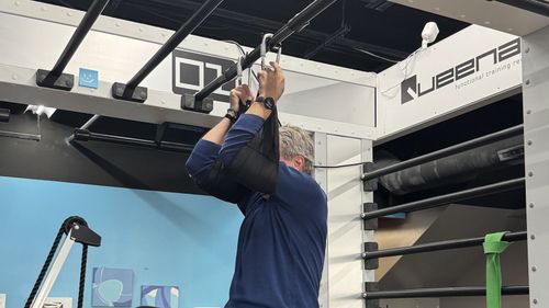 a man is doing a pull up on a bar in a gym