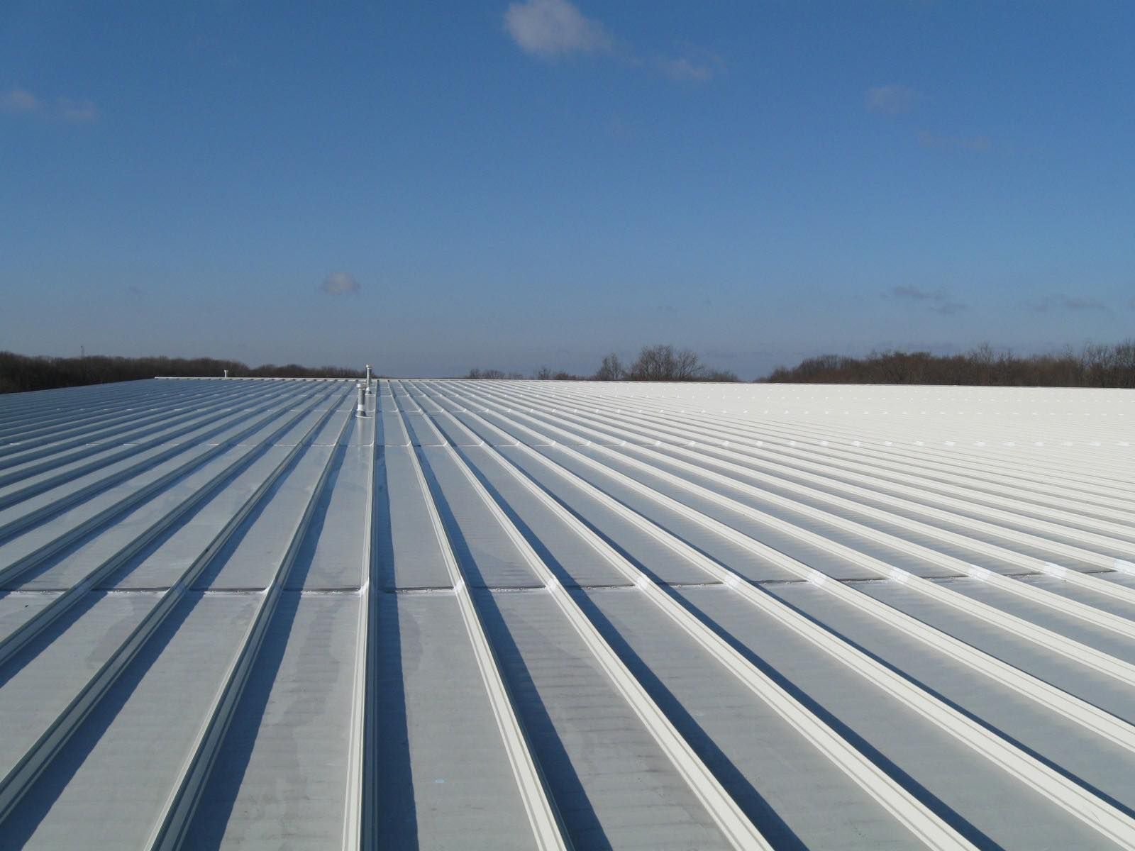 Metal roof with ribbed pattern on a clear, sunny day.