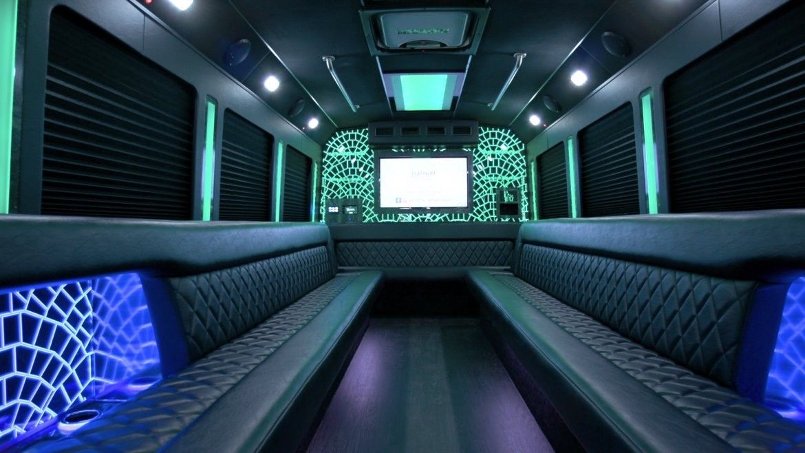 The inside of a limousine with a flat screen tv on the wall.