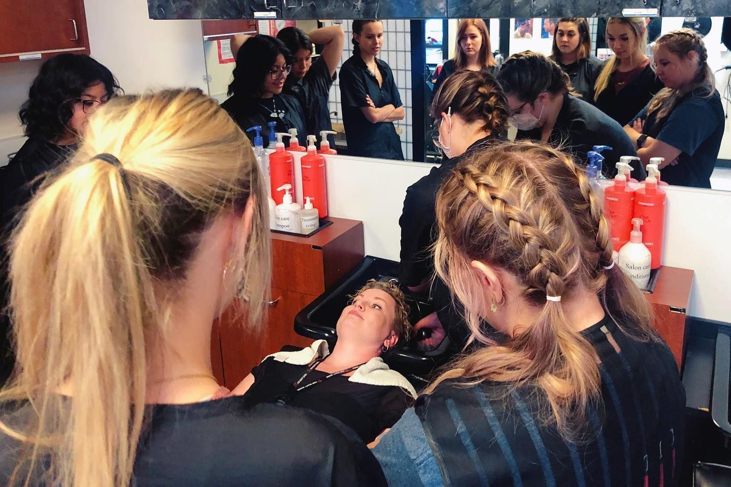 A woman is getting her hair washed in a sink in a salon.