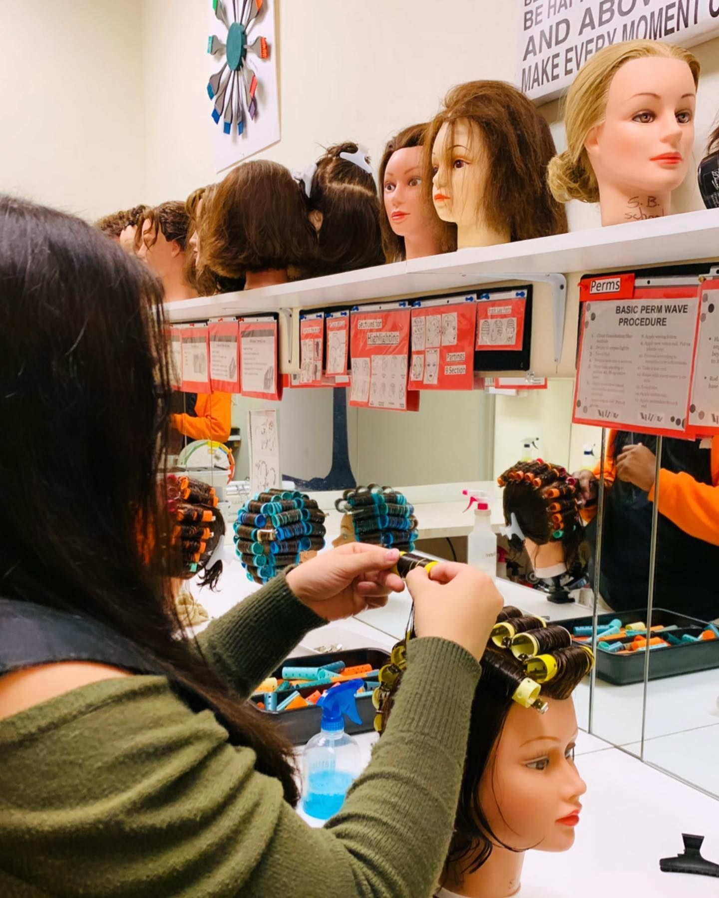 A woman is working on a mannequin 's hair in a salon