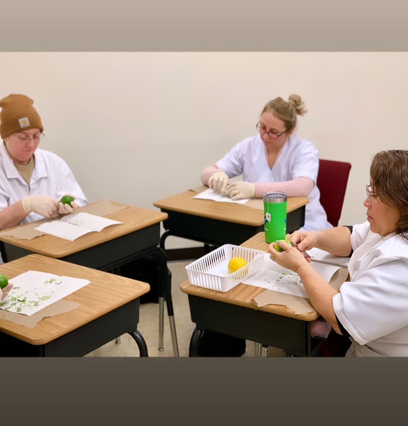 A group of people are sitting at desks in a classroom